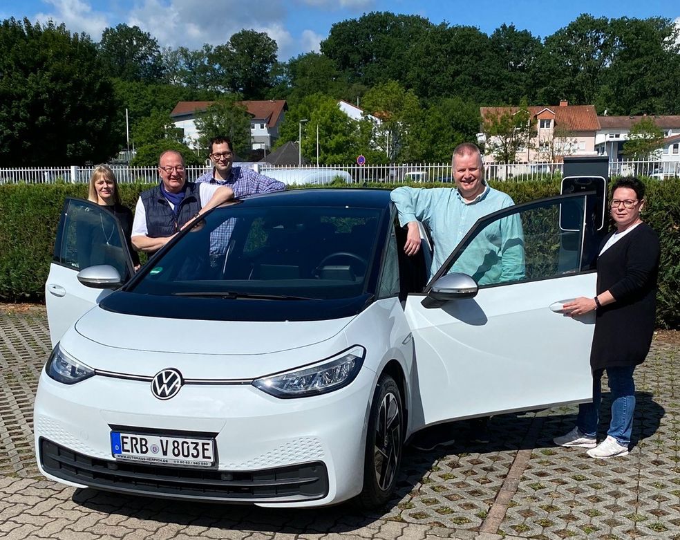 Übergabe des zweiten Elektrofahrzeugs, im Hintergrund die firmeneigene Ladestation